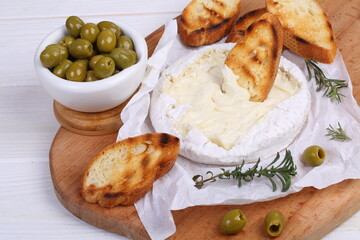 Camembert with toasted baguette on white background