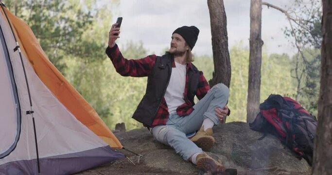 Young tourist makes selfie photo, video with the nature on the background