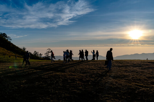 silhouette people on slope moutain peak to watch morning fog and sunrise at Phu Lom Lo, Thailand