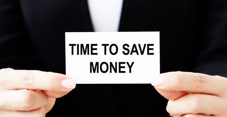 A businessman holds a business card with the text TIME TO SAVE MONEY in front of him.
