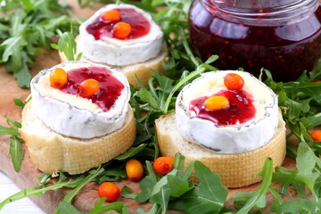 Cheese Saint-Mor-de-Touren with a glass of red wine on a white wooden background