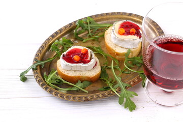 Cheese Saint-Mor-de-Touren with a glass of red wine on a white wooden background