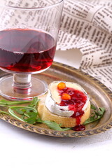 Cheese Saint-Mor-de-Touren with a glass of red wine on a white wooden background