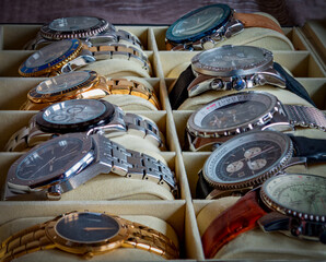 A row of mens watches sitting in a watch box