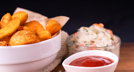 Tradition french fries from organic bio potato wedges with skin dip in ketchup