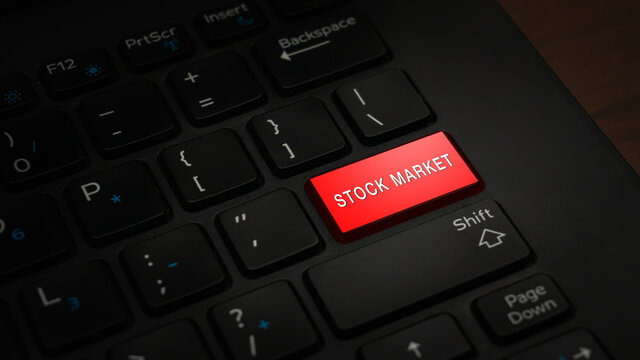 Close-up STOCK MARKET button with red color on a black laptop keyboard background. Conceptual photo of stock market and trading. Online business.