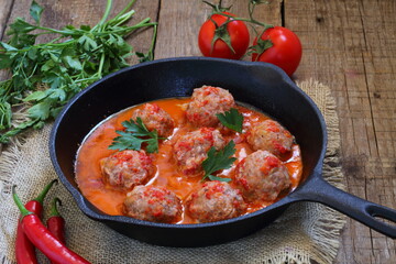 Meatballs in a ceramic plate with beer on a wooden table