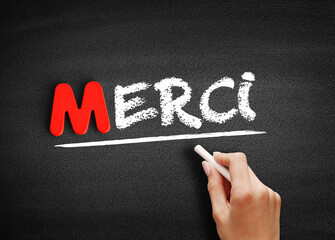 Merci (Thank You In French) text on blackboard, concept background
