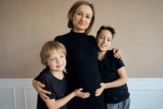 Beautiful pregnant woman with her sons. High quality photo. High quality photo