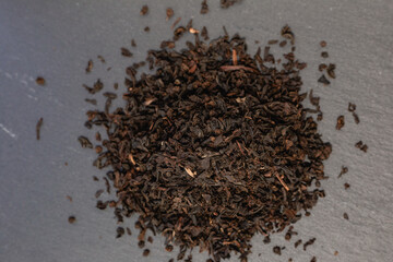 a slide of black tea on a dark stone background