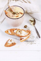 Obraz na płótnie Canvas French puree soup with parsnip, soft cheese baguette. Holds a soft cheese sandwich