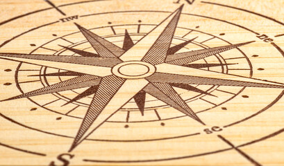 Macro shot of a compass painted on a wooden plank, small depth of field.