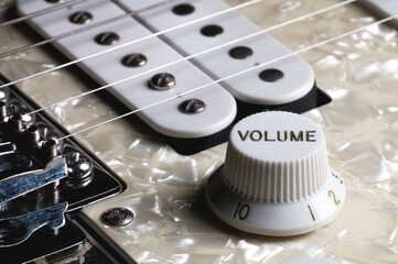 Close-up of electric guitar pickups and volume knob