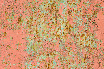 Old rusty metal wall with peeling and peeling red and burgundy paint