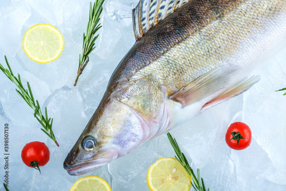 Wall mural raw fish is on ice cubes. poster with chilled raw fish with ice top view