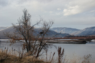 Beautiful winter landscape with snow-covered mountains, dry grass and a river in the foreground. Huntington, OR, USA