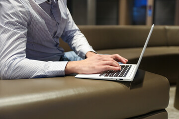 person's hands are typing on laptop in the waiting room
