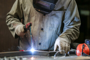 welder welds metal construction close up