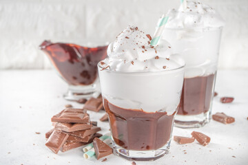 Hot chocolate milk shake, cold boozy cocktail with ice cream or whipped cream, with chocolate slices on white background copy space