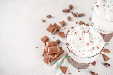 Hot chocolate milk shake, cold boozy cocktail with ice cream or whipped cream, with chocolate slices on white background copy space