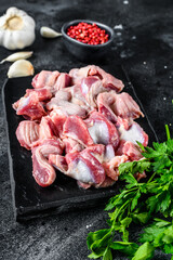 Raw uncooked chicken gizzards, stomach. Black background. Top view
