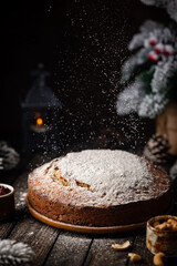 Traditional Christmas cake pudding with fruits and nuts with Christmas decorations, dark background
