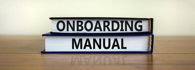 Onboarding manual symbol. Books with words 'onboarding manual' on beautiful wooden table. White background. Business and onboarding manual concept. Copy space.