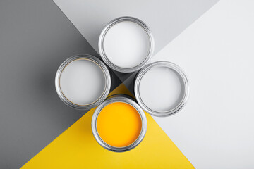 Demonstrating colors of year 2021 - Gray and Yellow. Four open cans of paint on bright symmetry...
