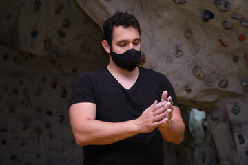 Man smearing his hands with magnesium powder getting ready to climb. Climbing at a climbing wall.