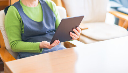 Japanese senior woman looking at tablet device
