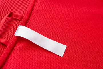 White blank clothes label on red jersey texture background