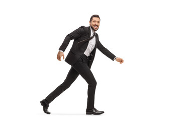 Handsome man in a black suit running and looking at camera