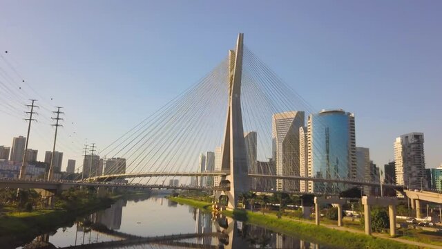 drone flight over the river on estaiada bridge in S&atilde;o Paulo during a sunset on a busy day