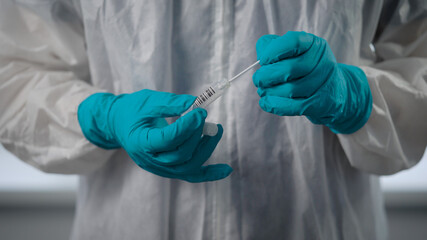Pandemic Covid-19. A close-up of the doctor's hand in protective gloves. The infectious agent holds a flask with the analysis of a sick person.
