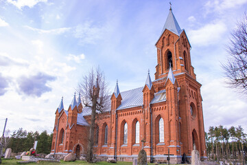 Fototapeta na wymiar Red brick church in the sun. Church of St. Alexei in the town of Ivenets, Belarus