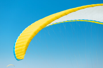Close-up of a paraglider wing and blue sky in the background. Concept of active recreation and equipment for air sports and extreme.