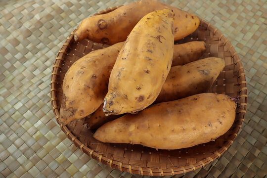 Ubi jalar kuning or yellow sweet potato on the pandanus mat. Selective focus