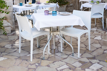 modern white chairs and dining table in restaurant. On terrace. 