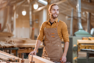 Portrait of a handsome carpenter at the joiner's shop