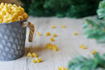 Raw noodles pasta rolls in a decorative bucket with Christmas branches