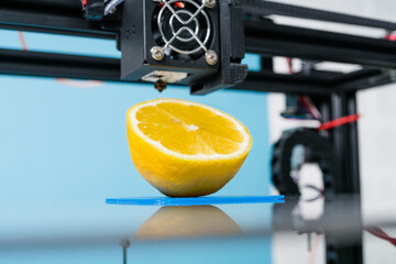 Ripe slice of yellow lemon citrus fruit . 3d printer of the device during the processe - 398518733