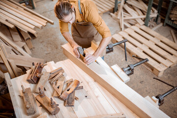 Carpenter working with a wood in the workshop