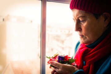 lonely and nostalgic senior woman putting up christmas decorations for christmas