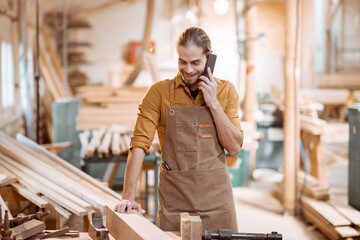 Carpenter with phone in the workshop