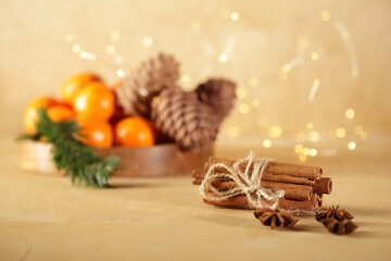 Chrismas mood still life: cinnamon, anise, tangerines, pine cones in golden christmas lights