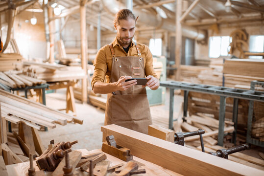 Carpenter with phone in the workshop