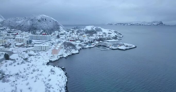 Breathtaking aerial drone footage. Flying over the industrial (fishery), seaside part of Alesund, the most beautiful town of Norway in winter time while everything is covered in a thick layer of snow.