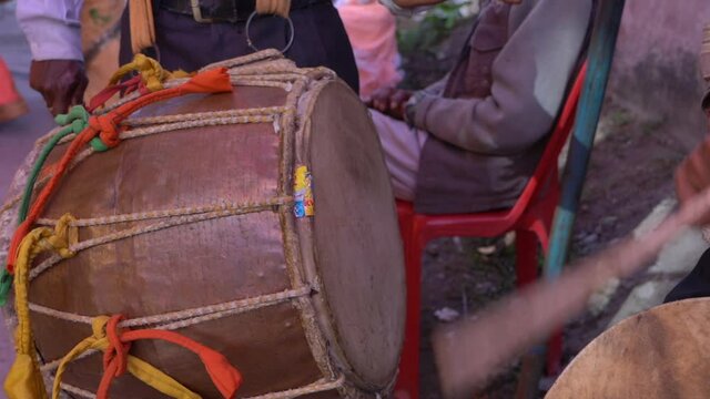 Artists playing traditional in musical instrument Dhol at a wedding in India.