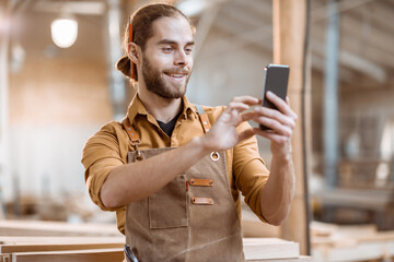 Carpenter using phone in the workshop