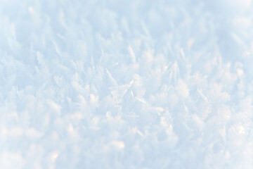 Hoarfrost background texture. Fresh ice and snow winter backdrop with snowflakes and mounds. Seasonal wallpaper. Frozen water geometrical shapes and figures. Cold weather atmospheric precipitation.
